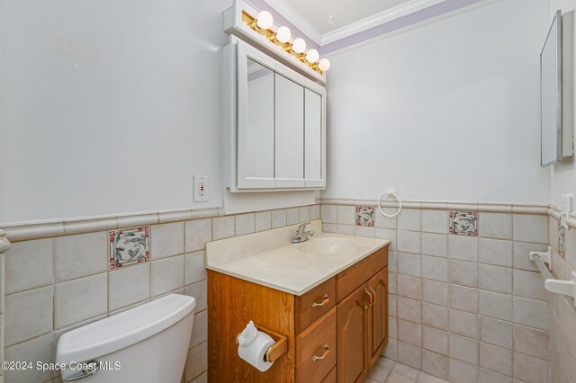 204 Queens Ct, Satellite Beach, FL 32937 - half bath with tile walls, vanity, toilet, ornamental molding, and a wainscoted wall