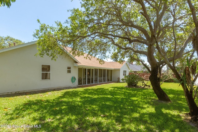 back of house with a lawn and a sunroom