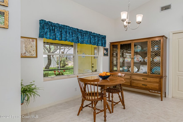 dining space featuring a notable chandelier, light tile patterned floors, and lofted ceiling