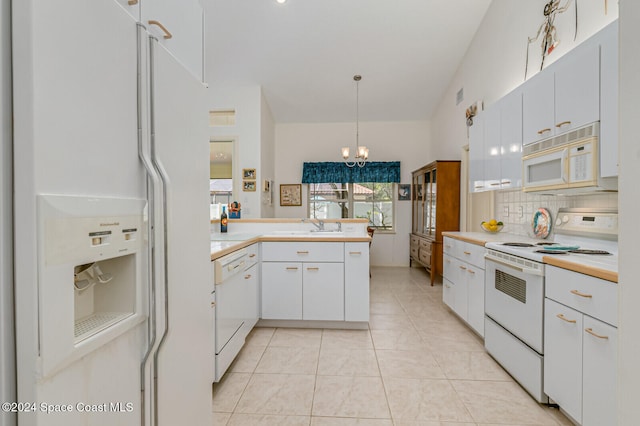 kitchen featuring white cabinetry, light tile patterned floors, an inviting chandelier, decorative light fixtures, and white appliances