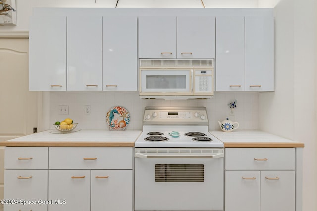 kitchen with white cabinetry, decorative backsplash, and white appliances