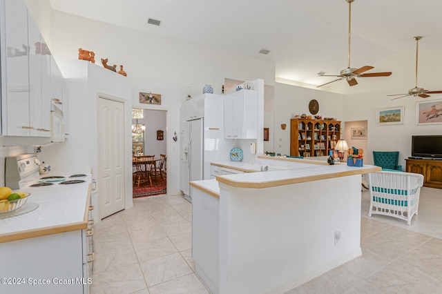 kitchen with white cabinetry, white appliances, light tile patterned floors, kitchen peninsula, and ceiling fan