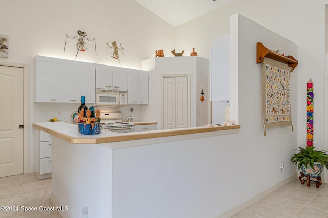 kitchen with white cabinetry, kitchen peninsula, white appliances, and light tile patterned floors