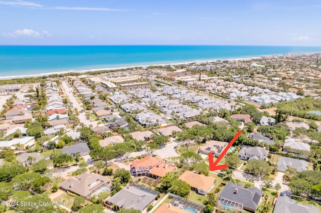 birds eye view of property with a water view and a beach view