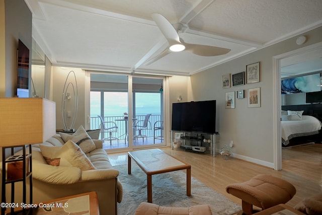 living room featuring a textured ceiling, ceiling fan, wood-type flooring, and ornamental molding