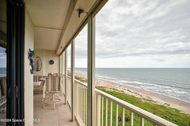 balcony featuring a beach view and a water view