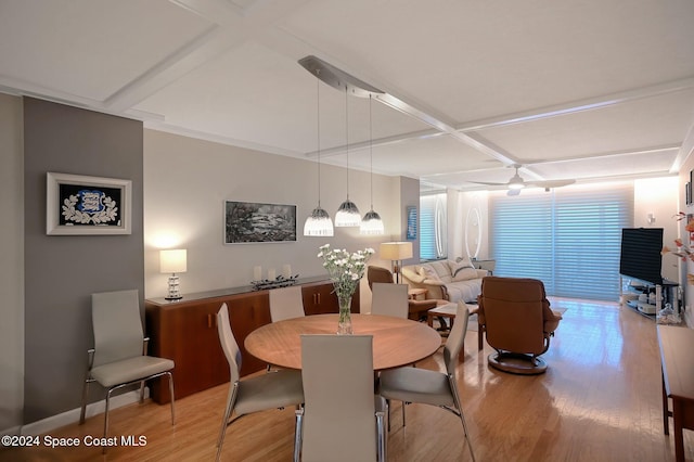 dining area featuring ceiling fan, wood-type flooring, and coffered ceiling