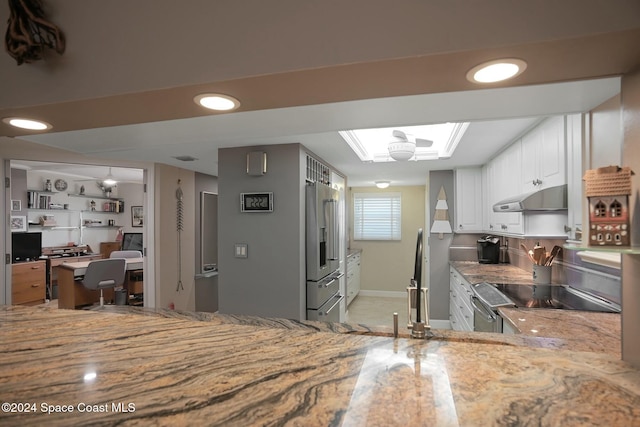 kitchen with kitchen peninsula, white cabinetry, high end fridge, and range