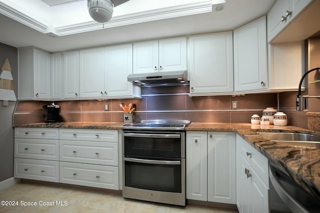 kitchen with white cabinets, sink, dark stone countertops, appliances with stainless steel finishes, and tasteful backsplash