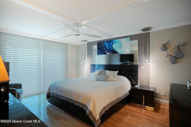 bedroom with beamed ceiling, ceiling fan, and wood-type flooring