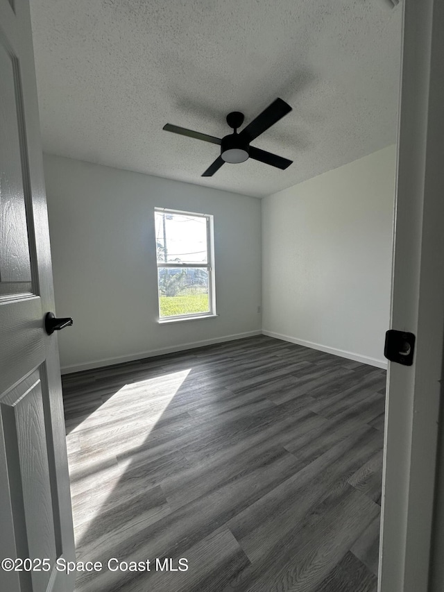 unfurnished room featuring a textured ceiling, ceiling fan, and dark wood-type flooring