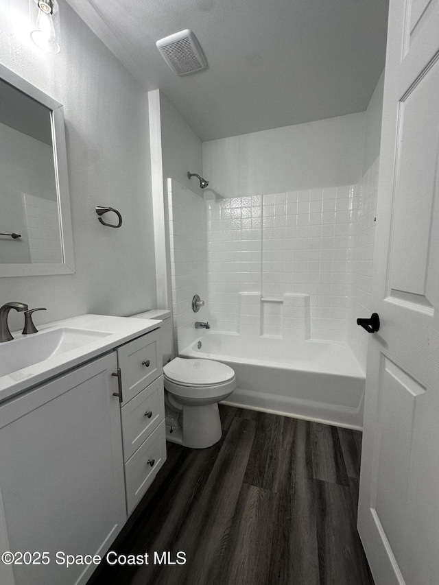 full bathroom with vanity, toilet, wood-type flooring, and tub / shower combination