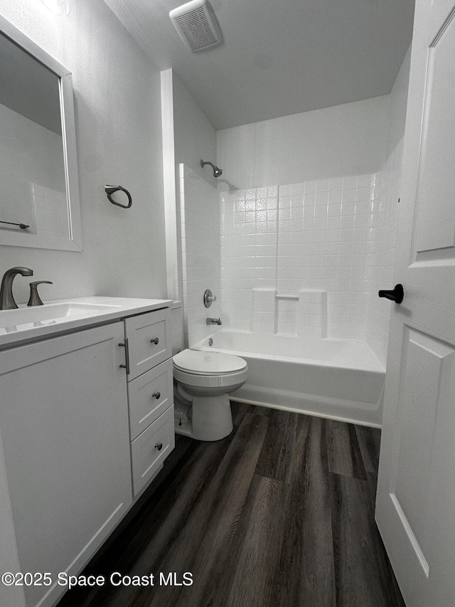 full bathroom featuring hardwood / wood-style flooring, vanity, toilet, and bathing tub / shower combination