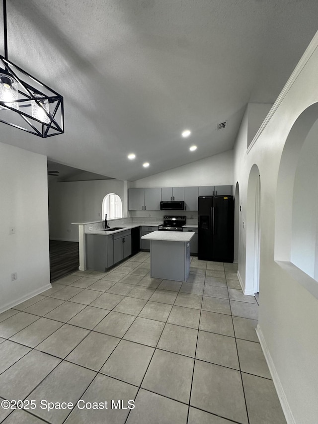 kitchen featuring vaulted ceiling, sink, black appliances, a center island, and gray cabinets