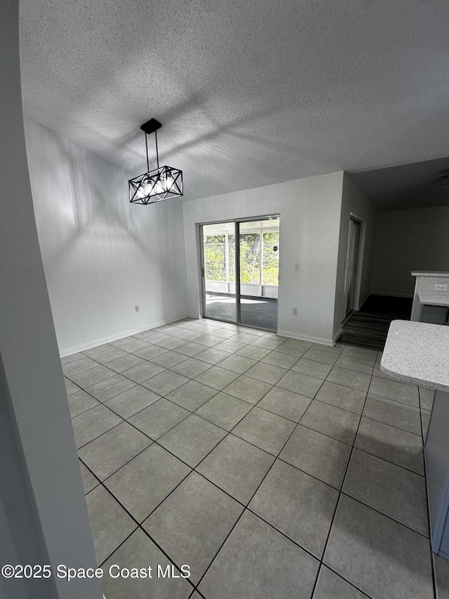 unfurnished dining area featuring light tile patterned flooring and a textured ceiling