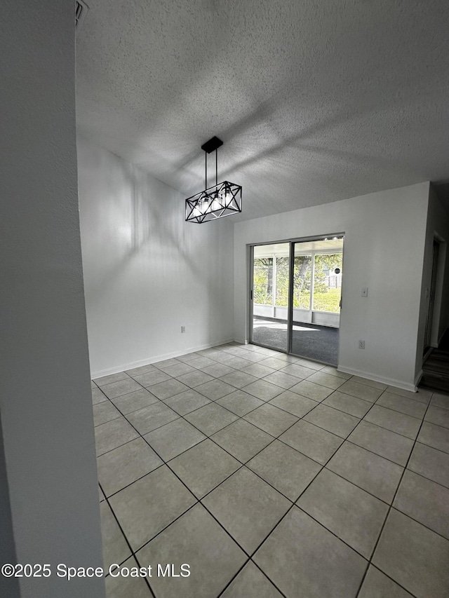 unfurnished dining area featuring light tile patterned flooring and a textured ceiling