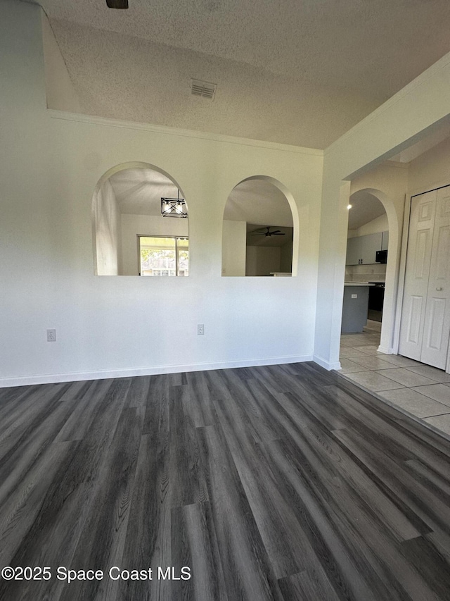 unfurnished room featuring crown molding, dark hardwood / wood-style flooring, and a textured ceiling