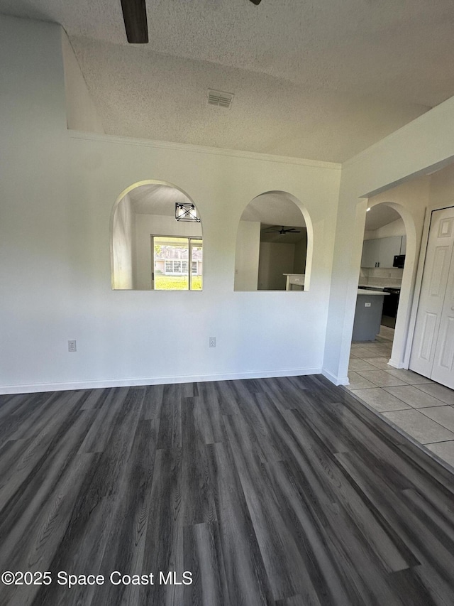 unfurnished room with dark hardwood / wood-style flooring and a textured ceiling