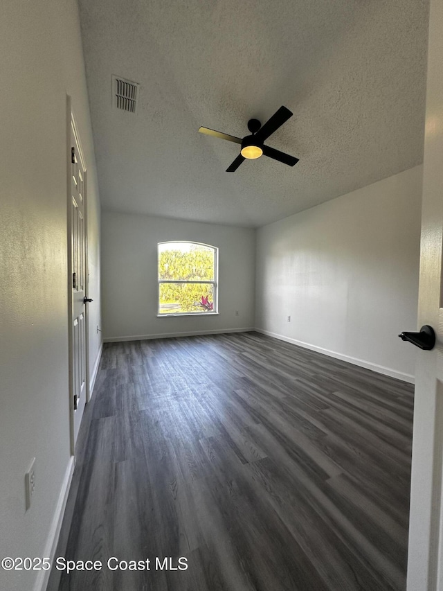 unfurnished room featuring ceiling fan, dark hardwood / wood-style flooring, and a textured ceiling