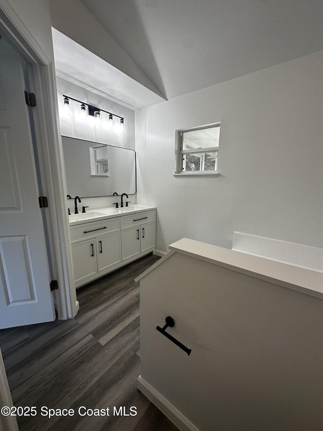 bathroom with hardwood / wood-style floors, vanity, and lofted ceiling