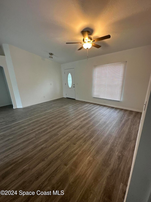 unfurnished living room featuring ceiling fan and dark hardwood / wood-style flooring