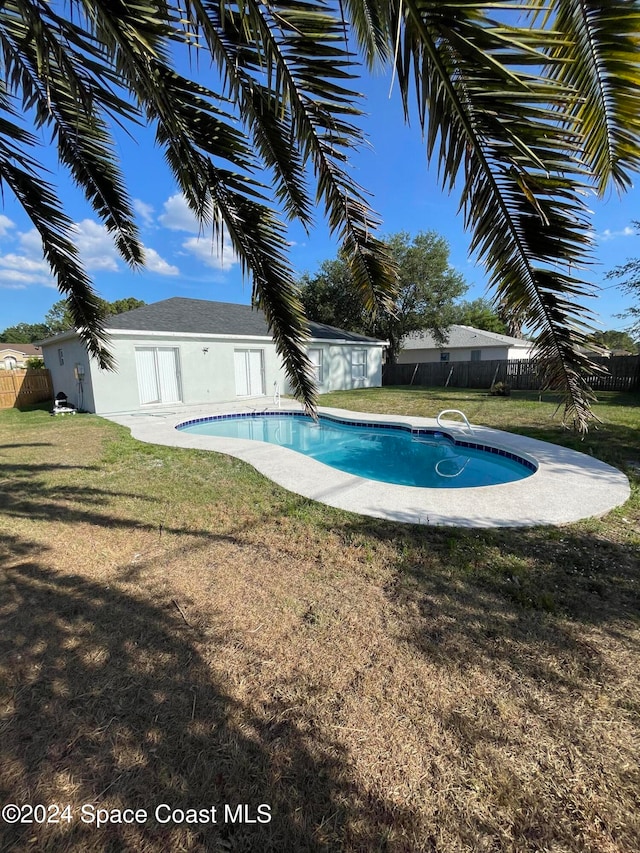 view of swimming pool with a yard