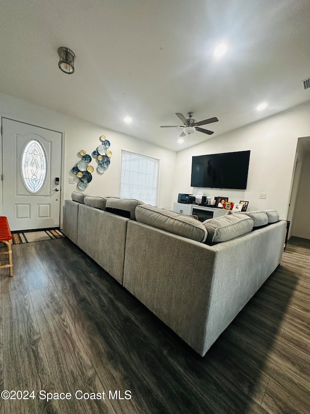 living room with ceiling fan and dark wood-type flooring