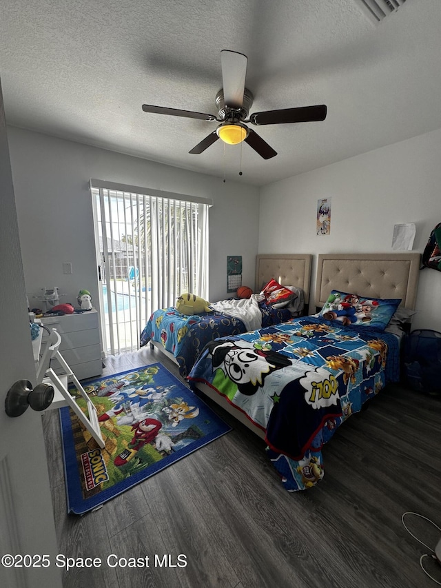 bedroom with ceiling fan, dark hardwood / wood-style floors, and a textured ceiling