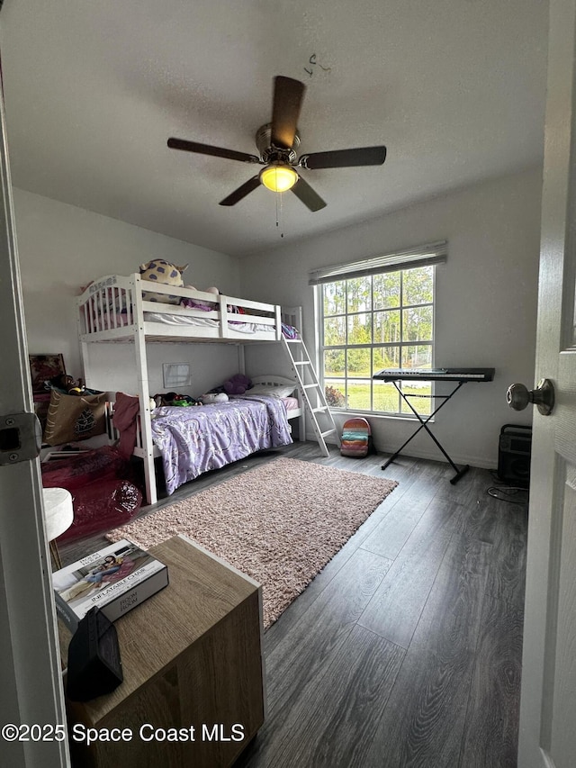 bedroom with hardwood / wood-style floors, ceiling fan, and a textured ceiling