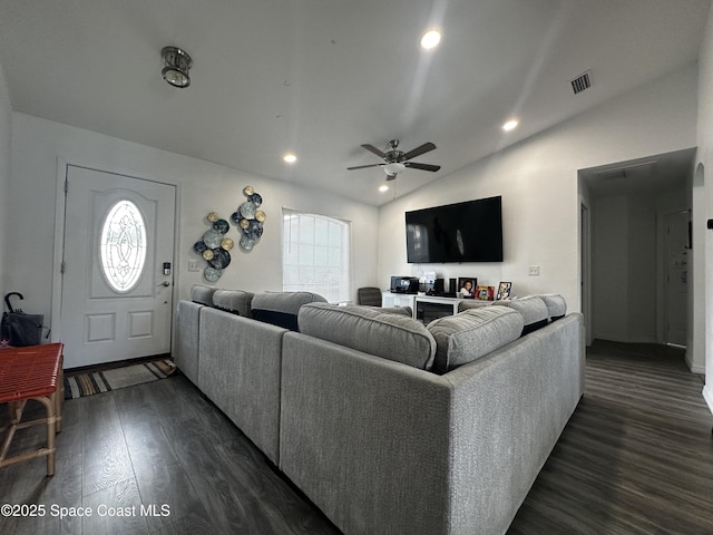 living room featuring ceiling fan, dark hardwood / wood-style flooring, and vaulted ceiling