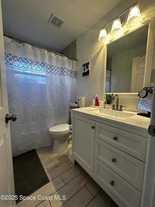 bathroom featuring vanity, curtained shower, and toilet