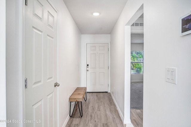 corridor with light hardwood / wood-style floors