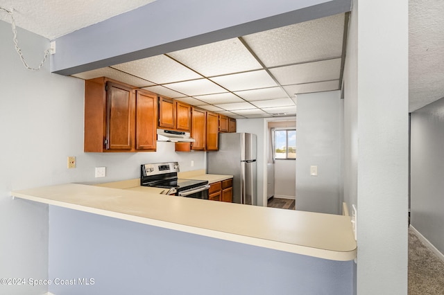 kitchen featuring carpet flooring, kitchen peninsula, and appliances with stainless steel finishes