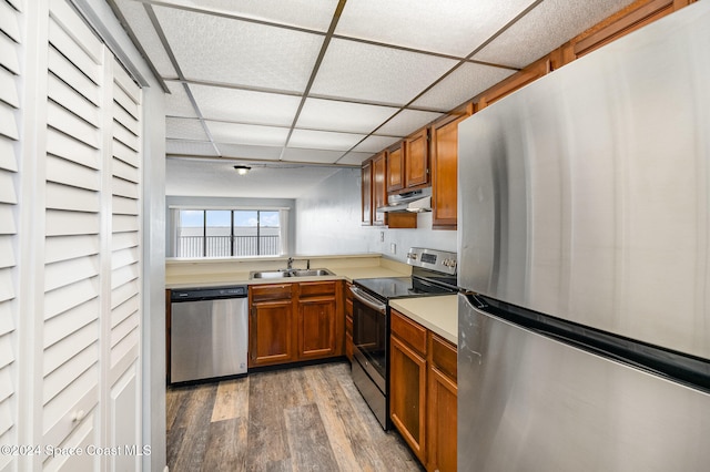 kitchen with dark hardwood / wood-style floors, a drop ceiling, sink, and appliances with stainless steel finishes