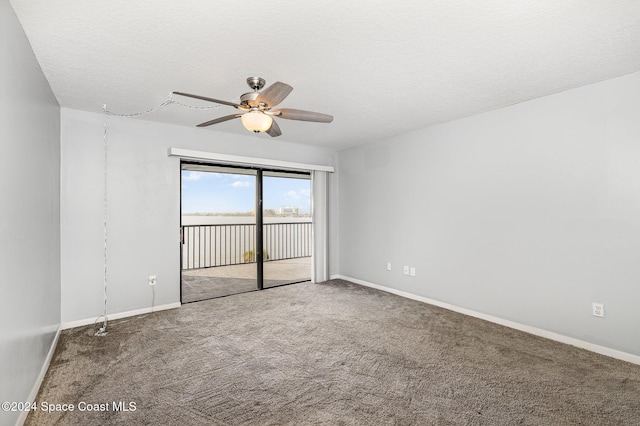 carpeted spare room featuring ceiling fan and a textured ceiling