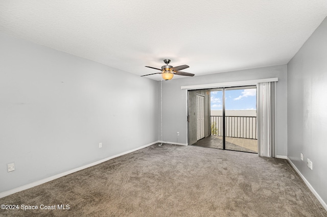 carpeted spare room featuring ceiling fan and a textured ceiling