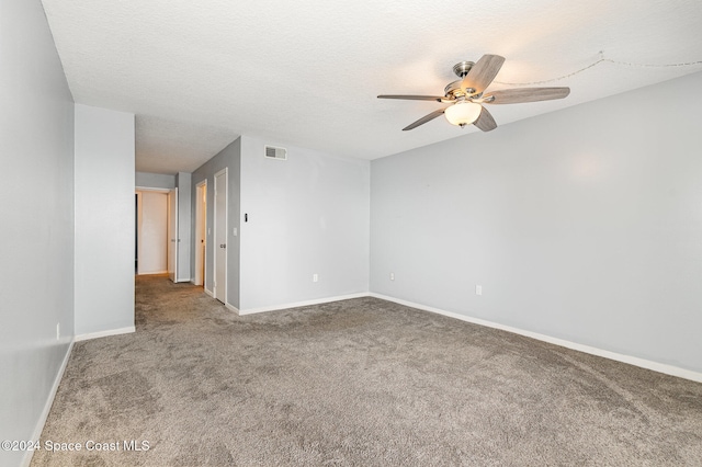 carpeted spare room featuring ceiling fan and a textured ceiling