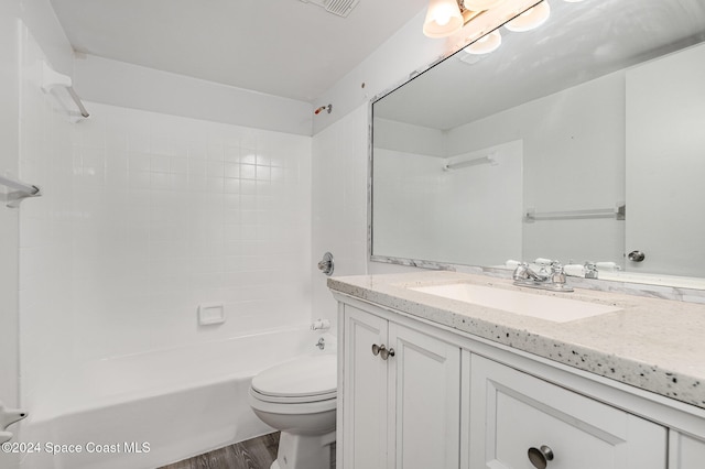 full bathroom with vanity, toilet, tiled shower / bath, and hardwood / wood-style flooring