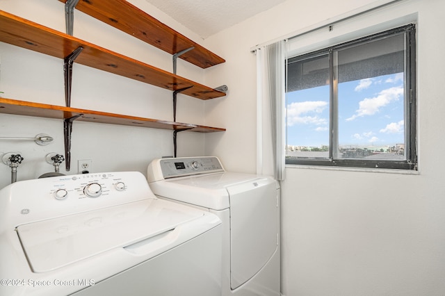 laundry area featuring a textured ceiling and washing machine and clothes dryer