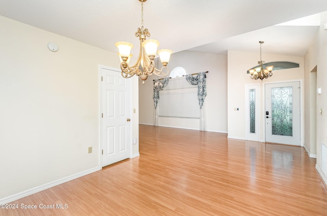 interior space featuring hardwood / wood-style floors, lofted ceiling, and a notable chandelier