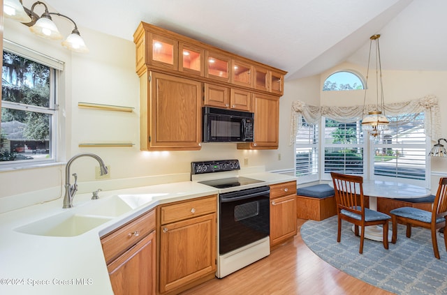 kitchen featuring a wealth of natural light, decorative light fixtures, white electric range oven, and vaulted ceiling