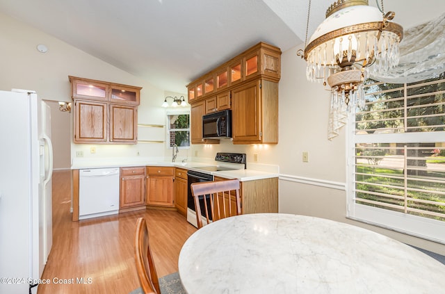 kitchen with sink, white appliances, vaulted ceiling, and light hardwood / wood-style floors