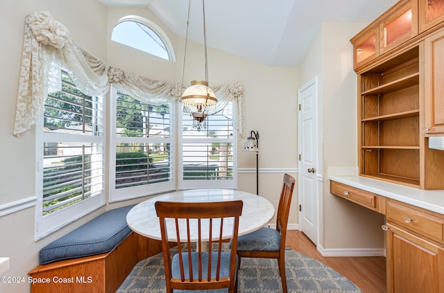 dining space featuring a wealth of natural light, a chandelier, light hardwood / wood-style flooring, and lofted ceiling