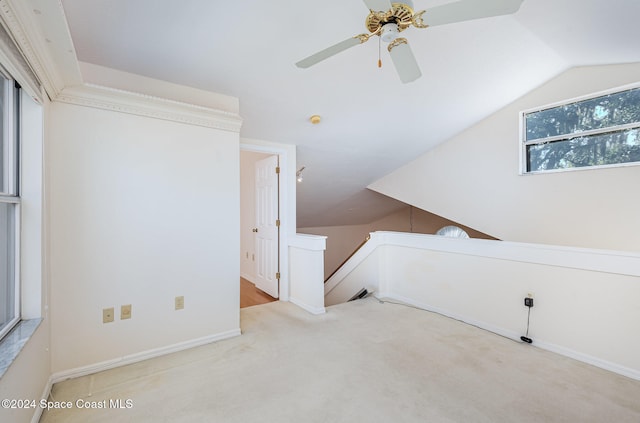 additional living space with a wealth of natural light, light carpet, ceiling fan, and vaulted ceiling