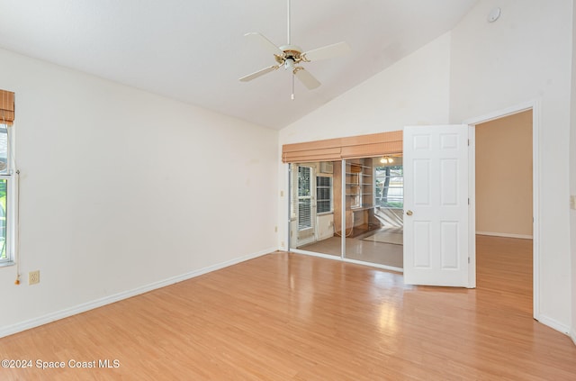 spare room featuring light hardwood / wood-style floors, ceiling fan, and high vaulted ceiling