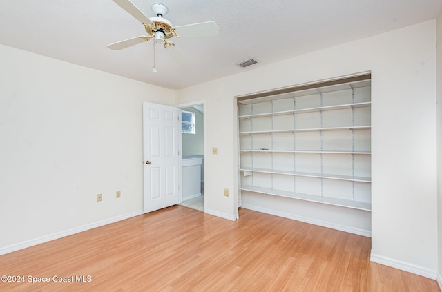 unfurnished bedroom with a textured ceiling, wood-type flooring, and ceiling fan