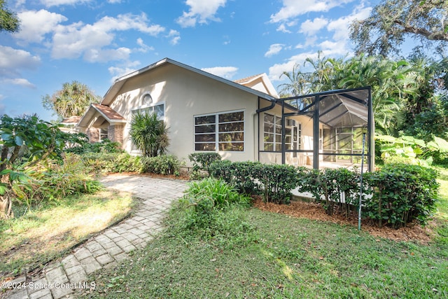 view of home's exterior with glass enclosure