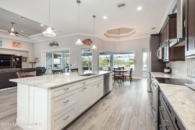 kitchen featuring sink, stainless steel appliances, hanging light fixtures, dark brown cabinets, and white cabinets