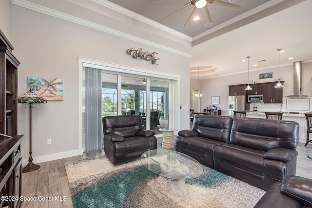 living room with ceiling fan, wood-type flooring, and crown molding