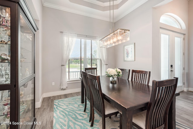 dining space with crown molding, french doors, and light hardwood / wood-style floors